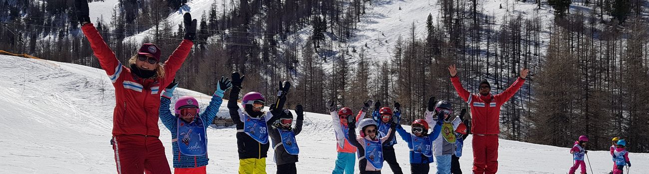 Groupe d'enfants en ski sur les pistes et leur moniteur